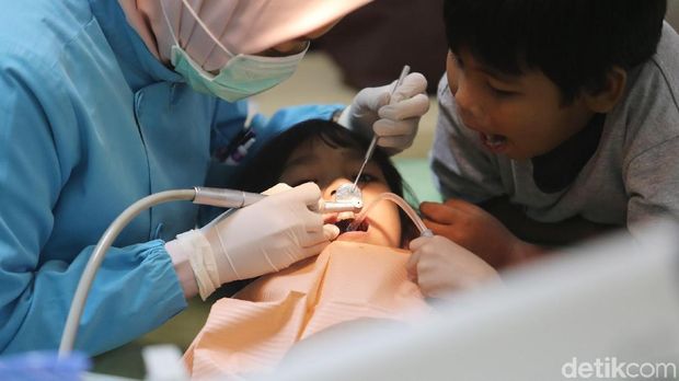 Para pasien anak-anak hingga dewasa memadati pemeriksaan dan penindakan gigi-mulut secara cuma-cuma di Salemba, Jakarta, Rabu (4/10/2017). Kegiatan yang berlangsung sejak Senin (2/10) tersebut untuk meramaikan Bulan Kesehatan Gigi Nasional. Sejumlah tindakan medis secara gratis tersebut seperti penambalan sederhana yang tidak melibatkan perawatan syaraf gigi, pencabutan tanpa komplikasi gigi sulung/gigi tetap, pembersihan karang gigi dan perawatan pencegahan gigi berlubang dengan aplikasi fluoride atau Fissure Sealant. (Ari Saputra/detikcom)