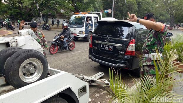 Penindakan juga dilakukan dengan derek kendaraan yang parkir di trotoar