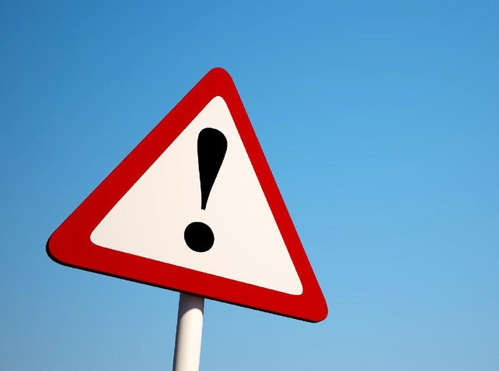 Warning Sign isolated on clean blue sky