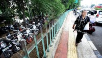 Seorang pejalan kaki tengah melintas dipedestrian yang bersebelahan dengan taman di depan pusat grosir Cililitan (PGC), Jakarta, Rabu (4/10/2017).