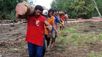Petugas harus melewati hutan untuk menuju desa yang akan dialiri listrik. (PLN).