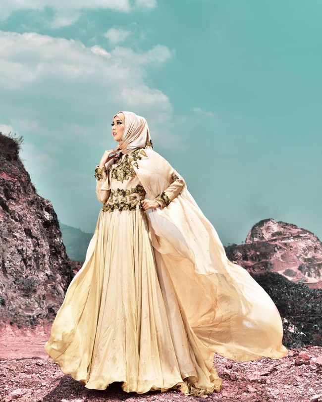 Mencoba gaun pengantin syari bernuansa gold rancangan Qonita Gholib. (Dok. Instagram @qonitagholib_official)