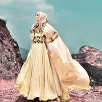 Mencoba gaun pengantin syari bernuansa gold rancangan Qonita Gholib. (Dok. Instagram @qonitagholib_official)