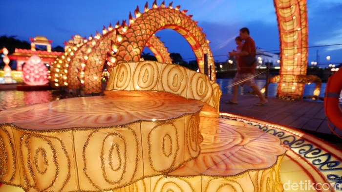 Pengunjung berfoto dan menikmati suasana lampion perahu naga Pluit Lantern Festival di Pluit Village, Jakarta Utara, Rabu (4/10). Acara tersebut bertepatan dengan Mooncake Festival 2017 atau perayaan kue bulan (zhong qiu) yang jatuh pada 4 Oktober. Mooncake Festival menjadi salah satu perayaan penting dalam penanggalan Tiongkok seperti Imlek, Cap Go Meh atau Peh Cun.
