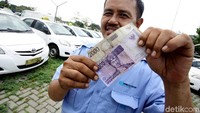 Seorang supir memperlihatkan struk bukti setoran dan uang sisa hasil kerja semalam 24 jam yang cuma sisa Rp 12.000.