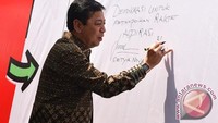 Jam tangan Novanto terlihat jelas saat Ketum Golkar itu menulis di kain yang diduga untuk mengesahkan alun-alun demokrasi dan memotong pita peresmian proyek itu. (Foto: ANTARA FOTO/Hafidz Mubarak A)