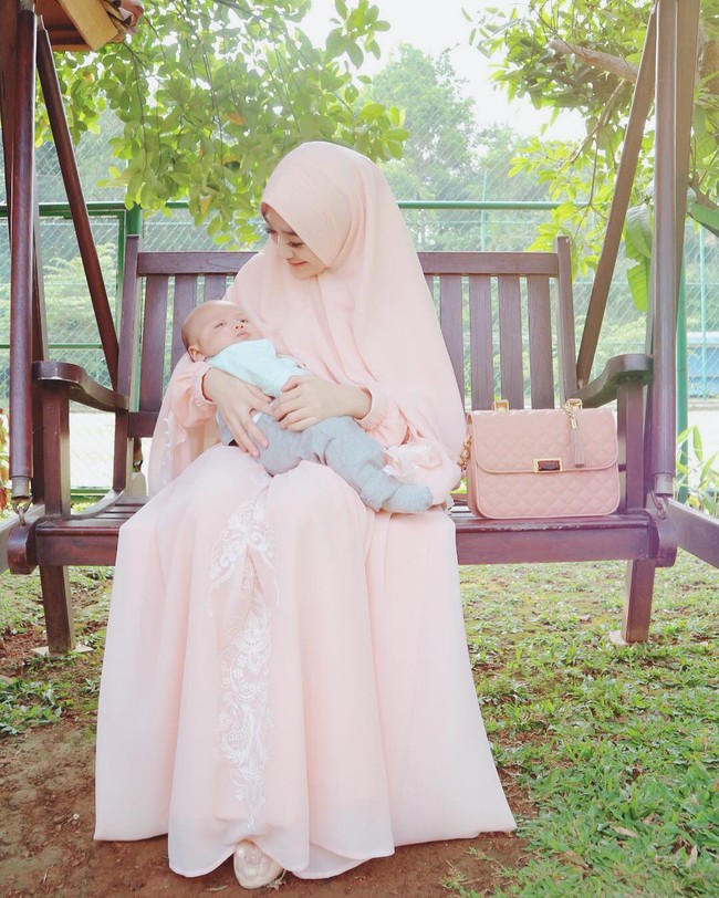 Bergaya feminin dengan pilihan hijab syari seperti Larissa Chou. Ia memilih palet peach untuk tampil cerah ketika pergi di siang hari bersama keluarga tercinta. Sentuhan bordir memberikan kesan yang semakin anggun dan tak monoton. Foto: Dok. Instagram @alvin_411