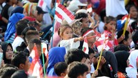 Anak-anak mengibarkan bendera Merah Putih.