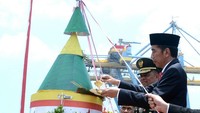 Jokowi kemudian memotong tumpeng berukuran besar sebagai penanda HUT TNI.
