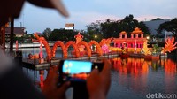 Pengunjung berfoto dan menikmati suasana lampion perahu naga Pluit Lantern Festival di Pluit Village, Jakarta Utara, Rabu (4/10).