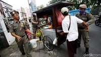 Petugas Satpol PP saat menggelar penertiban trotoar di kawasan Ciracas, Jakarta Timur, Jumat (6/10/2017).