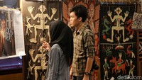 Dua orang pengunjung melihat-lihat kain tenun yang dipamerkan.