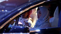Seorang wanita Saudi menggunakan handphone-nya saat dia memeriksa sebuah mobil (Reuters/Faisal Al Nasser)