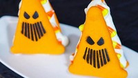 Imutnya! Macaron dibuat bentuk segitiga menyerupa hantu. Nuansa oranye dan hitamnya lekat sekali dengan Halloween.