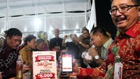 Gubernur DKI Jakarta, Djarot Saiful Hidayat menikmati makanan usai bertransaksi dengan pembayaran non tunai JakOne Mobile didampingi Direktur Bisnis Bank DKI Antonius Widodo Mulyono di lokasi binaan Taman Kota Intan di Jakarta, Kamis 5 Oktober 2017 malam. Foto: dok. Pemprov DKI