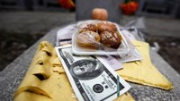 Serta juga ada yang meletakan uang palsu dan beberapa kue di atas kuburan (Jason Lee/Reuters)
