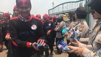 Buruh yang berdemo tersenyum saat diberi permen oleh polwan. Foto: Yogi Irfandi/detikcom