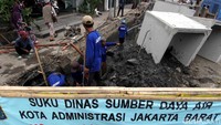 Pekerja mengangkat tanah ke atas untuk bok saluran air yang baru.