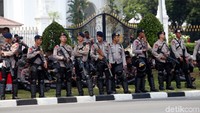 Sejumlah aparat kepolisian yang dilengkapi senjata api laras panjang berjaga-jaga di depan Istana Negara.