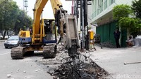 Alat berat menghancurkan saluran air yang lama.