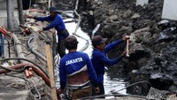 Pekerja memperbaiki saluran air Jalan Hayam Wuruk, Jakarta.
