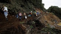 Warga harus berjalan kaki karena jalanan terputus diterjang longsor. REUTERS/Juan Carlos Ulate.