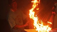 Salah satu penampil yang tengah membakar dupa. Nantinya dupa itu akan ditancapkan ke kepala dan badan naga api (Randy/detikTravel)
