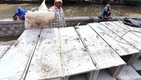 Pekerja mengerjakan pembetonan dengan teknik sheet pile (turap) di bibir Kali Pengairan, Rawa Tembaga, Kota Bekasi, Minggu (8/10). Pembetonan dilakukan untuk memperkuat fungsi sungai.  