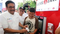 Gubernur Provinsi DKI Jakarta, Djarot Saiful Hidayat bersama Direktur Utama Bank DKI, Kresno Sediarsi dan wajib pajak menunjukan proses pembayaran Pajak Kendaraan Bermotor via ATM Bank DKI di Monas Jakarta, Minggu (8/10/2017). Foto: dok. Pemprov DKI