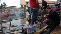 Warga lokal di Carolina, Puerto Riko, mengantre untuk mengisi botol plastik mereka dengan air saat distribusi air bersih di Bayamon usai Badai Maria. (Foto: REUTERS/Alvin Baez)