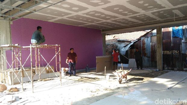 Pekerja masih tampak mengecat bangunan.