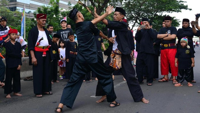 Sejumlah aktivis dari Dewan Kesehatan Rakyat bersama para pesilat menunjukan atraksi beladiri betawi saat sosialisasi dan kampanye stop informasi salah tentang susu berkadar gula tinggi di Senayan, Jakarta, Minggu (8/10). Aksi tersebut dilakukan guna menghimbau warga agar pentingnya melindungi anak-anak dari bahaya Susu Kental Manis yang tinggi gula dan miskin zat gizi.