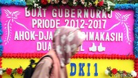 Seorang warga tengah melintas di depan karangan bunga.