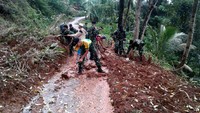 Prajurit Kostrad membersihkan material longsor di akses jalan Dusun Cikokol-Cikamulan Desa Kali Jati, Kabupaten Pangandaran, Jawa Barat, Senin (9/10/2017). (Penkostrad).