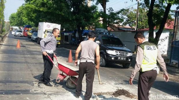 Polisi tambal jalan berlubang di Pantura, Pekalongan.