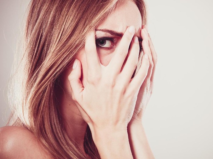 Depressed woman pressing her hand against her forehead