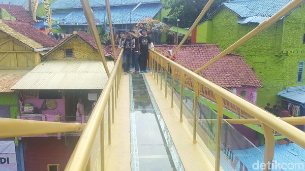 Jembatan kaca Malang memiliki panjang 20 meter, lebar 1,25 meter, yang berada di ketinggian 9,5 meter. Jembatan ini menjadi penghubung Kampung Warna-Warni dan Tridi di Kota Malang. (Muhammad Aminudin/detikcom)