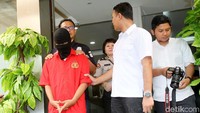 MHS (19) dihadirkan dengan memakai penutup kepala.