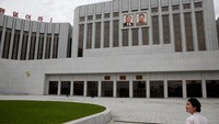 Bangunannya terlihat biasa saja, berwarna putih dengan foto Kim Il Sung dan Kim Jong Il di bagian depan gedung. Bahkan, gedung ini terlihat monoton (Damir Sagolj/Reuters)