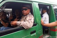 Polisi duduk di depan untuk mengawal angkot di Kabupaten Bandung. 