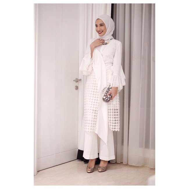 Menghadiri pernikahan Laudya Cynthia Bella, Zaskia Sungkar tampil elegan dengan busana serba putih dengan detail laser cut. Ia kembali memilih hijab segi empat yang diikat ke belakang. Foto: Dok. Instagram/ZaskiaSungkar