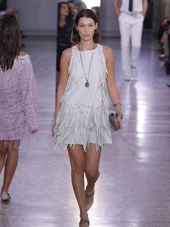 Bella Hadid dalam balutan dress putih beraksen fringe di fashion show Bottega Veneta.