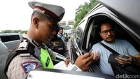 Polisi memeriksa surat-surat kendaraan yang terjaring razia.