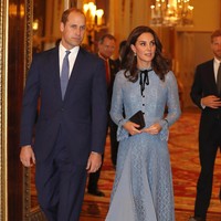 Sepatu pumps dan clutch hitam melengkapi gayanya yang tampak serasi dengan pita di kerah yang juga berwarna hitam. Foto: Getty Images