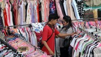 Seorang pengunjung tengah memilih baju bekas.