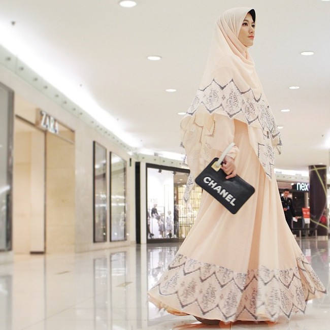 Inspirasi model hijab syari untuk kondangan lainnya bisa melihat gaya Lyra Virna yang satu ini. Ia memanfaatkan gamis warna krem dan clutch hitam. Lihat motif yang tercetak di atas khimar dan model terlihat menarik. Foto: Dok. Instagram @lyravirna