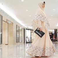 Inspirasi model hijab syari untuk kondangan lainnya bisa melihat gaya Lyra Virna yang satu ini. Ia memanfaatkan gamis warna krem dan clutch hitam. Lihat motif yang tercetak di atas khimar dan model terlihat menarik. Foto: Dok. Instagram @lyravirna