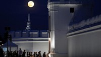 Bulan Purnama menyinari malam saat para masyarakat memberikan penghormatan terakhir kepada Mendiang Raja Bhumibol Adulyadej. Reuters/Athit Perawongmetha.