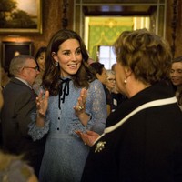 Aksen pita di bagian leher gaun membuat penampilannya semakin terlihat chic dan elegan. Foto: Getty Images