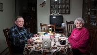 Frances dan Joan menikmati makanan di meja makan. Saat mereka makan terlihat televisi tak dinyalakan dan menikmati makanan dengan susu. Foto: Lois Bielefeld